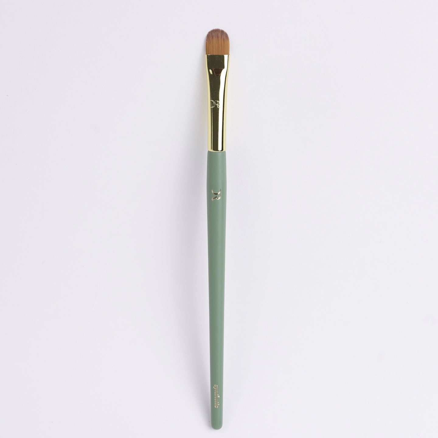 Precision flat synthetic makeup brush for spot concealing and under-eye blending.