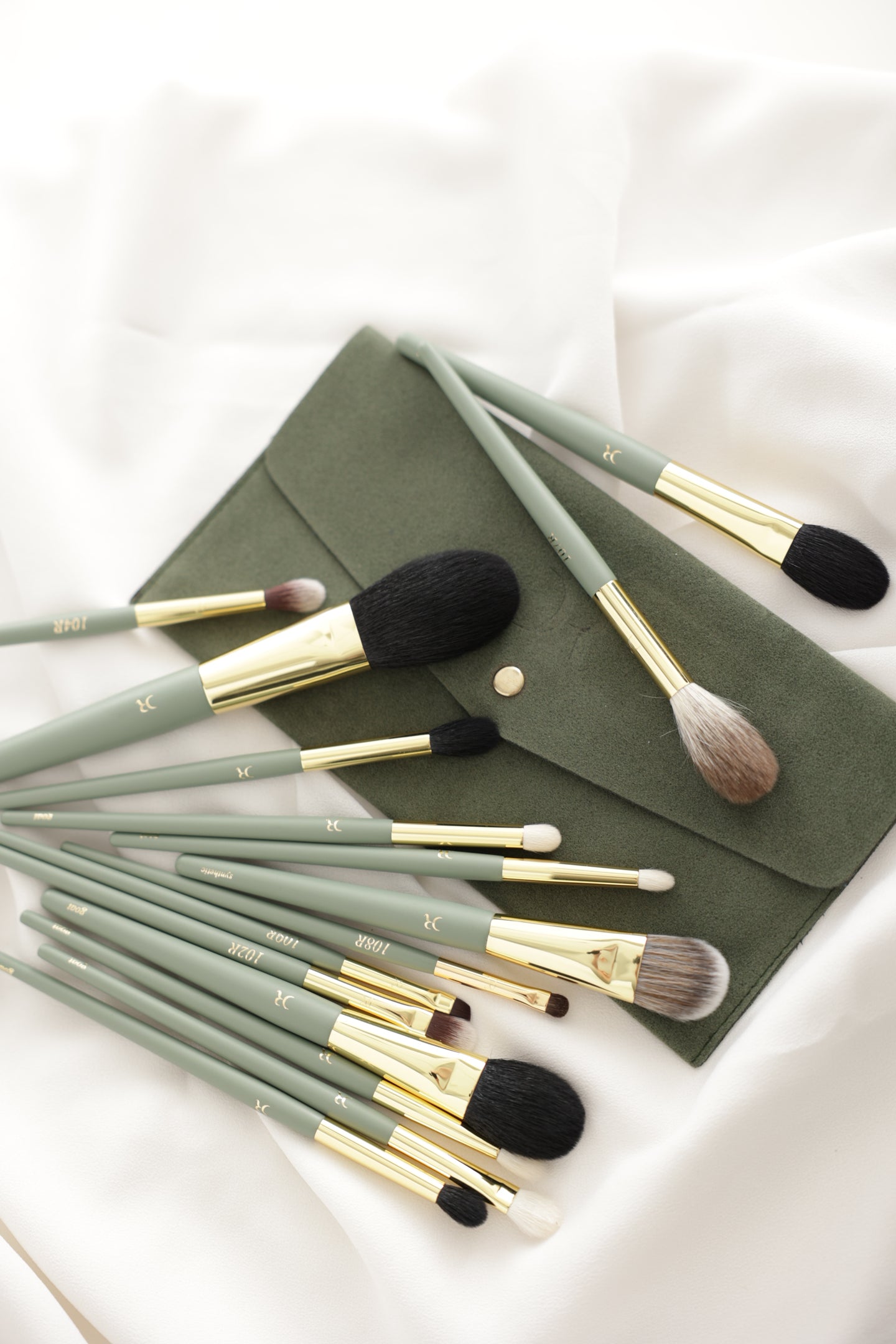 Dorina Rotari Pro-Create makeup brush set with green handles and travel pouch on white fabric