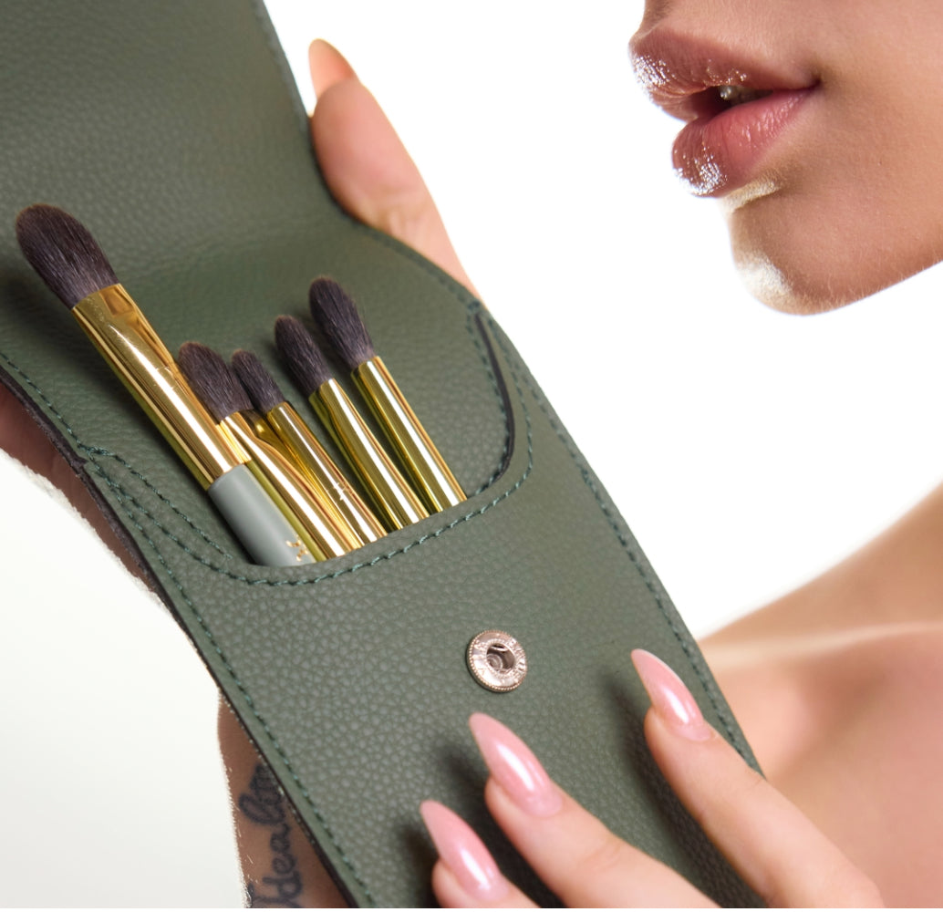 Dorina Rotari WHISPER TOUCH eye professional makeup brush set with soft bristles in a sage green pouch, held by model with glossy lips